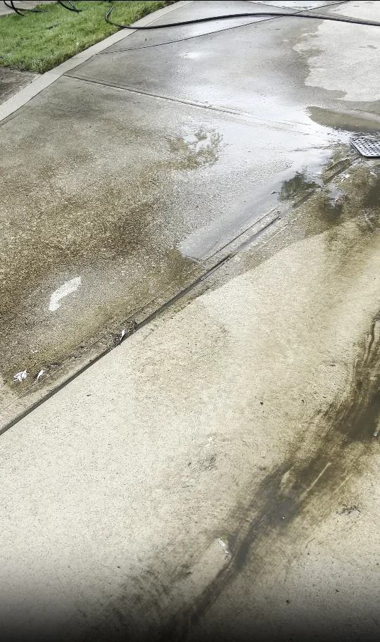 Wet concrete pavement being pressure washed